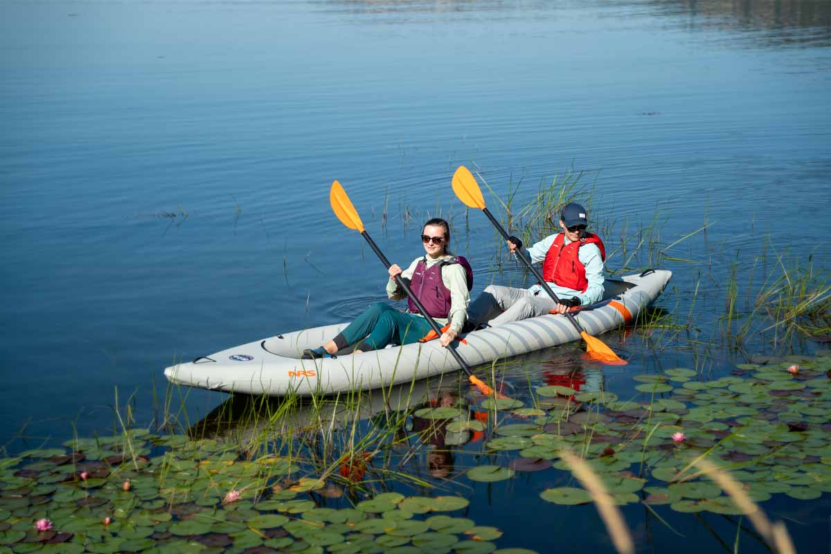 While floating through lily pads, a couple enjoys the sunshine in the NRS two-person Akamai 145 kayak.