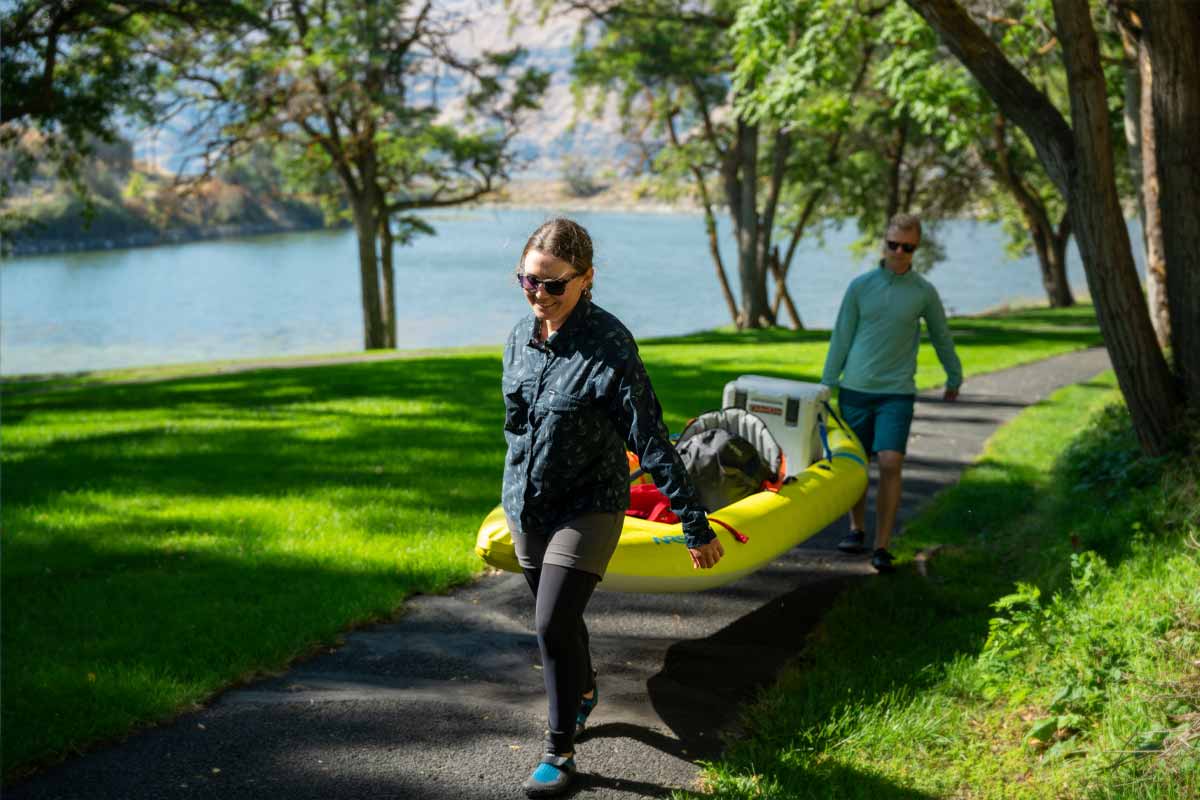 A man and woman carry the Kaholo 125 while loaded with gear.