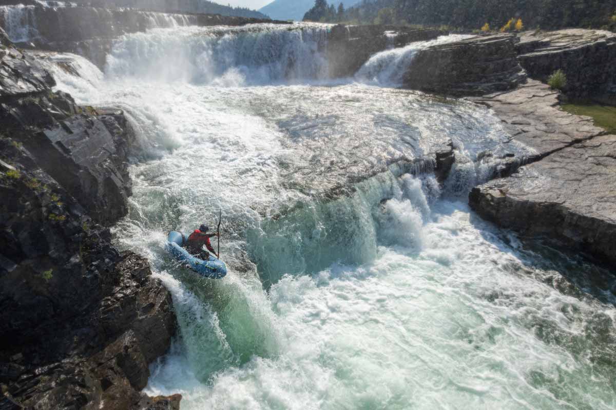 A paddler drops down misty rapids in the Neutron SL packraft.