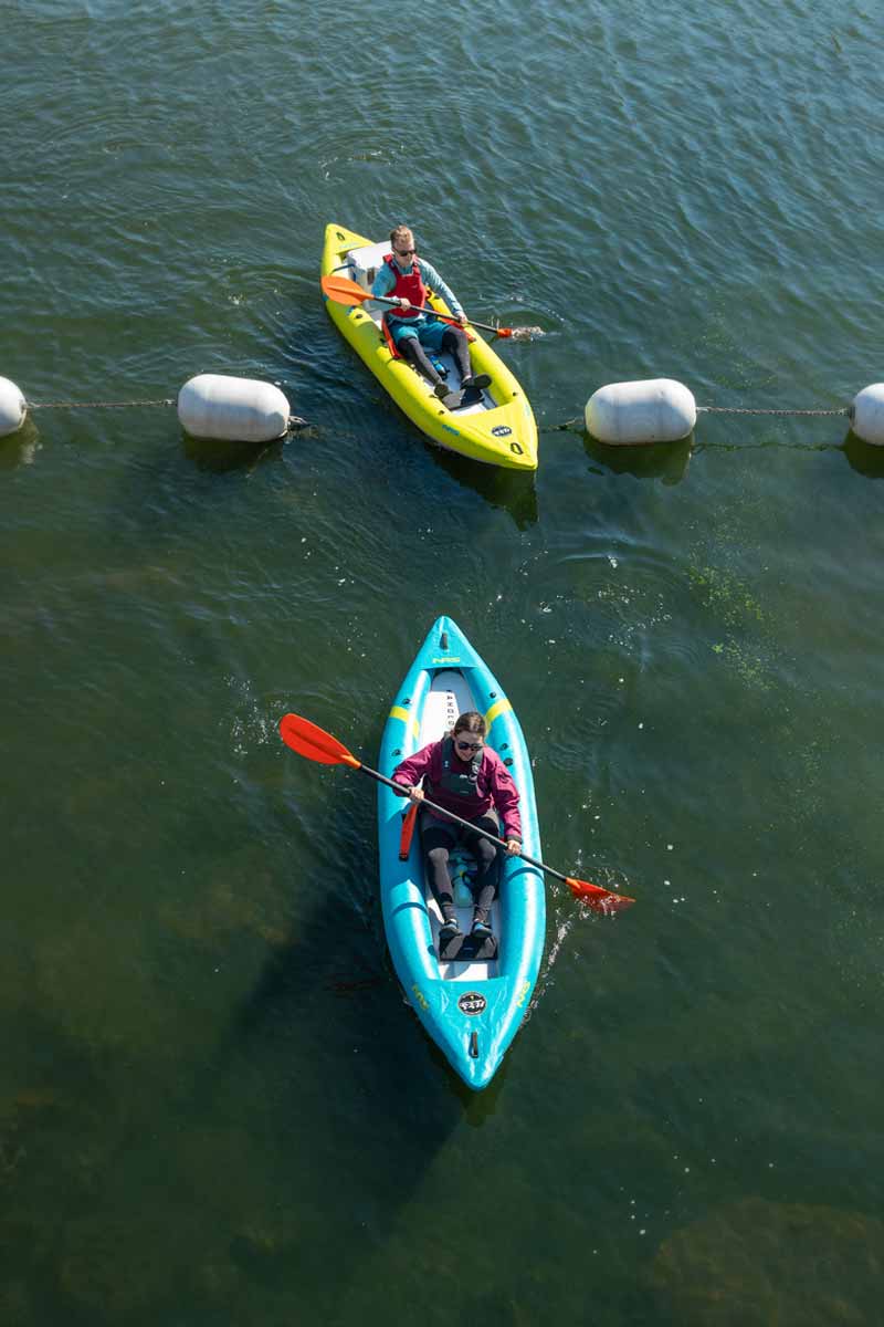 An aerial view of a couple paddling the Kaholo 110 and 125 over a rope float line.